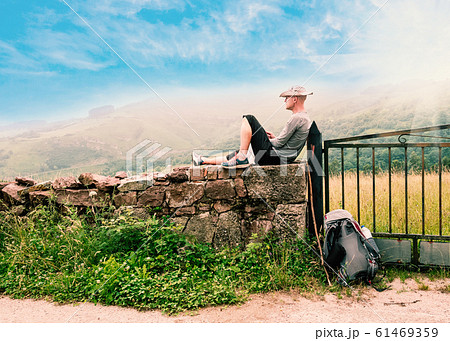 Lonely Pilgrim with backpack resting. Camino de Santiago Lonely Pilgrim with backpack resting. Camino de Santiago 61469359