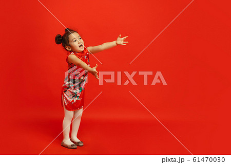 Happy Chinese New Year. Asian little girl portrait isolated on red background 61470030