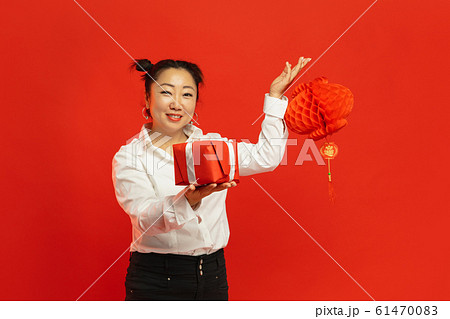 Happy Chinese New Year. Asian young woman portrait isolated on red background 61470083