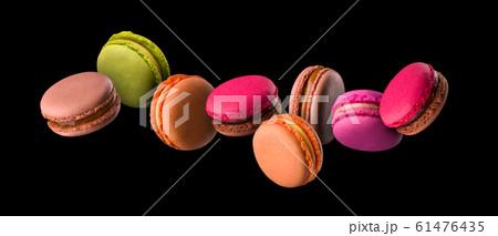 Flying french colorful macaroons on wooden table isolated on black 61476435