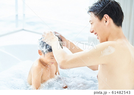 泡風呂に入る父子 明るい浴室の写真素材