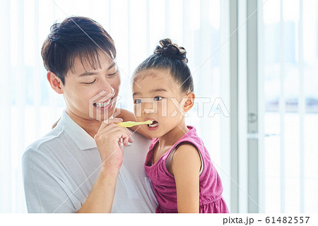 娘の歯を磨く父親　明るい室内 61482557