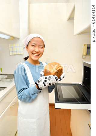 キッチンでパンを焼く女の子 キッチンでパンを焼く女の子 61484114