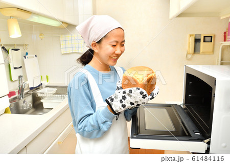 キッチンでパンを焼く女の子 61484116