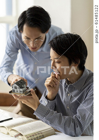 一級建築士の勉強をする若い男性に住宅の実務設計を通して人材育成に取り組むビジネスマン 一級建築士の勉強をする若い男性に住宅の実務設計を通して人材育成に取り組むビジネスマン 61485122