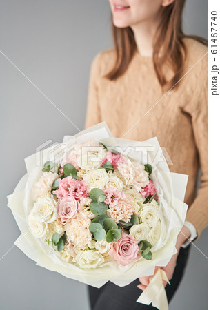 European floral shop. Beautiful bouquet of mixed flowers in womans hands. the work of the florist at a flower shop. Delivery fresh cut flower. European floral shop. Beautiful bouquet of mixed flowers in womans hands. the work of the florist at a flower shop. Delivery fresh cut flower. 61487740