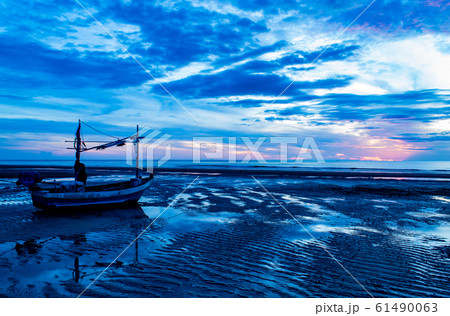 The morning sun light in the sea and the boat on the beach. The morning sun light in the sea and the boat on the beach. 61490063