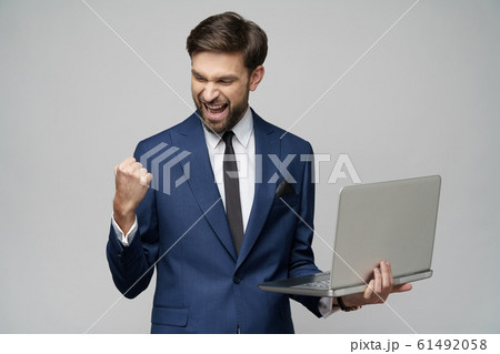 Young handsome businessman Holding a laptop Computer with Blank Screen 61492058