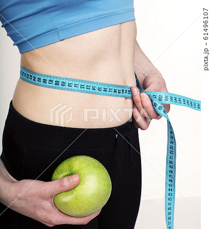 woman waist measuring tape holding apple woman waist measuring tape holding apple 61496107