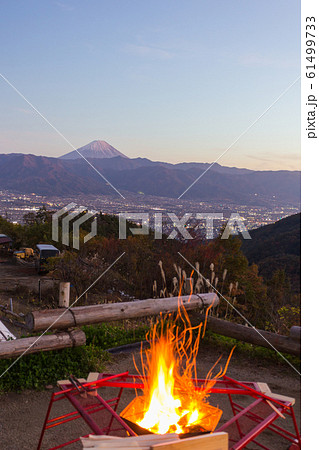 山梨のキャンプ場で夕方の紅色に染まる富士山と焚き火 61499733