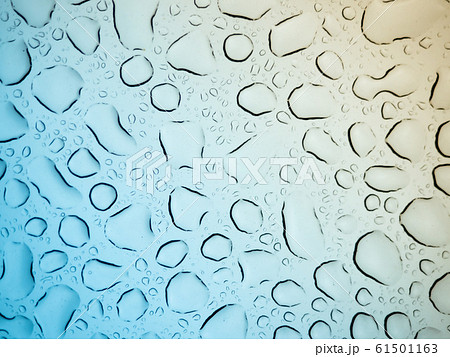 Close up view of water drops falling on glass Close up view of water drops falling on glass 61501163