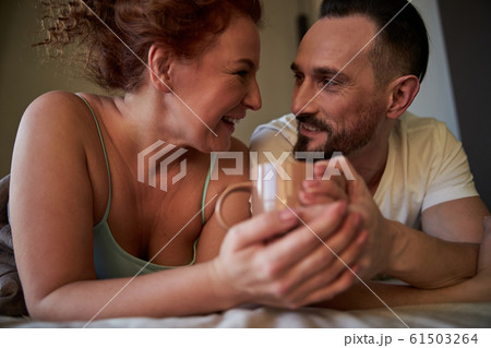 Adult couple spending a romantic morning in bed at home Adult couple spending a romantic morning in bed at home 61503264