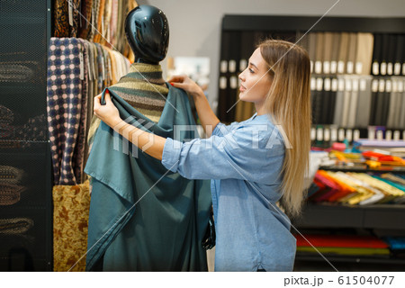 Seamstress with fabric at mannequin, textile store Seamstress with fabric at mannequin, textile store 61504077