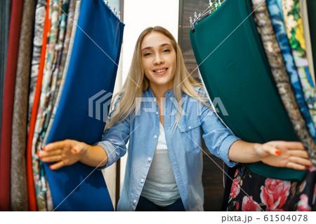 Woman between fabric in textile store Woman between fabric in textile store 61504078