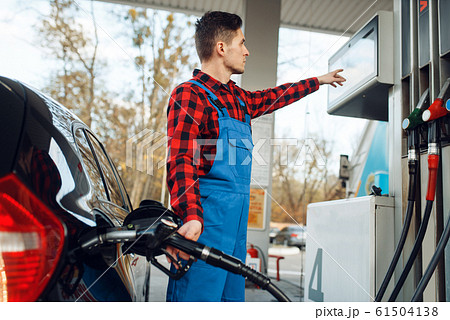 Male worker in uniform fuels car on gas station Male worker in uniform fuels car on gas station 61504138
