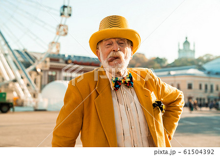 Smiling old man is making feces outdoors 61504392