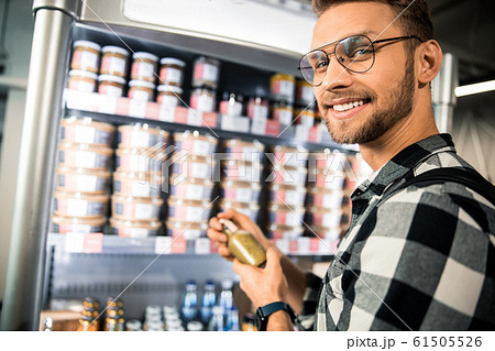 Happy young man choosing products in the store 61505526