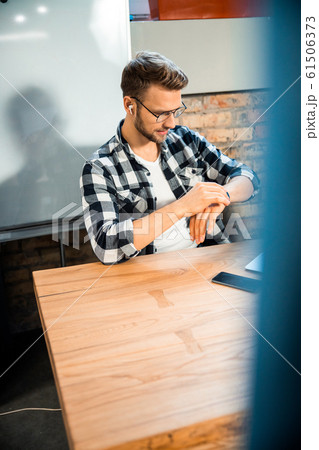 Young guy looking at smart watch in the office 61506373