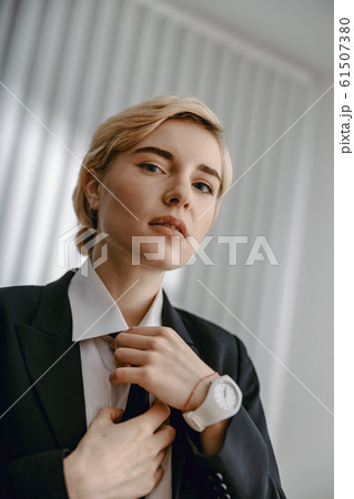 Serious businesswoman posing at camera in studio 61507380
