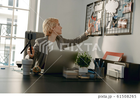 Smiling female blogger making video in the office 61508265