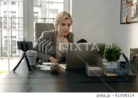 Pretty woman looking carefully at the screen Pretty woman looking carefully at the screen 61508314