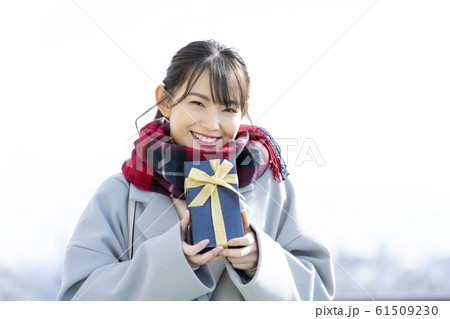 プレゼントを持った女性　冬のギフトイメージ 61509230