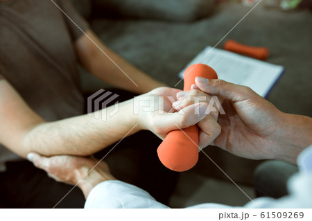 Asian young male physiotherapist helping patient 61509269