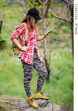 backpack girl holdig smart phone on mountain top. 61513671