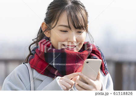 スマートフォンを操作する若い女性 61518826