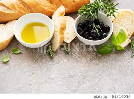 Sliced fresh crusty baguette with olive and spices Sliced fresh crusty baguette with olive and spices 61519050