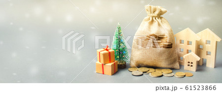 Money bag, wooden houses, Christmas tree and gifts. Christmas Sale of Real Estate. New Year discounts for buying housing. Purchase apartments at a low price. Holiday discounts. Favorable prices Banner Money bag, wooden houses, Christmas tree and gifts. Christmas Sale of Real Estate. New Year discounts for buying housing. Purchase apartments at a low price. Holiday discounts. Favorable prices Banner 61523866