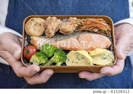 しゃけのり弁当を持つ男の人の手のアップ 61526312