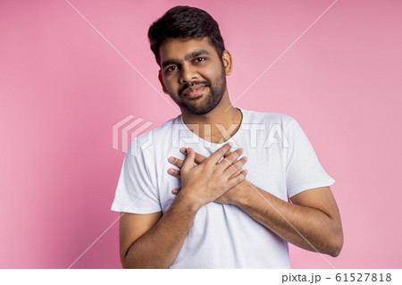 Portrait of handsome Indian guy standing on pink 61527818