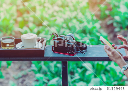 Hot coffee in a white cup and Chinese tea for a relaxing break for farmers in the afternoon on the terrace in the kale farm. Selective focus on left hand. Hot coffee in a white cup and Chinese tea for a relaxing break for farmers in the afternoon on the terrace in the kale farm. Selective focus on left hand. 61529443
