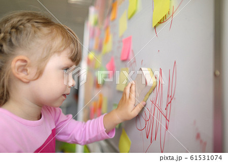 Little girl erases lettering 61531074