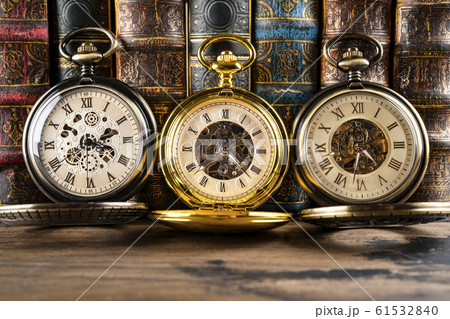 Antique clocks on the background of vintage books. 61532840