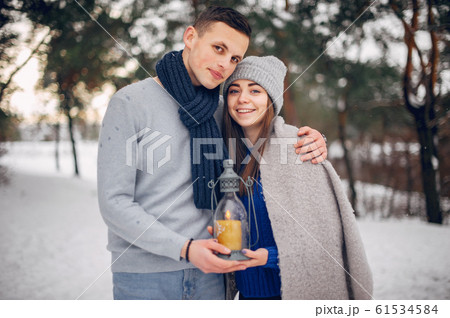 Cute and loving couple in a winter forest Cute and loving couple in a winter forest 61534584