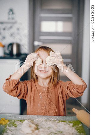 Little girl cook the dough for cookies 61535005