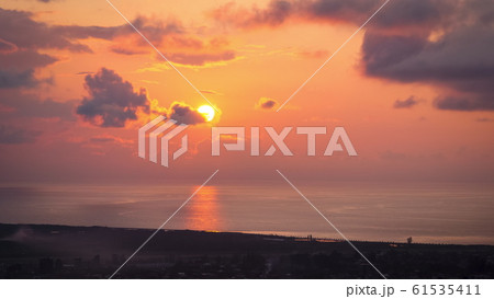 Timelapse of Sunset in the Clouds over the Sea and the City, aerial view. 61535411