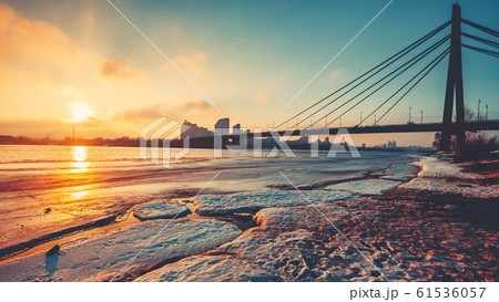 Pivnichnyi Bridge silhouette over half frozen Dnipro river 61536057