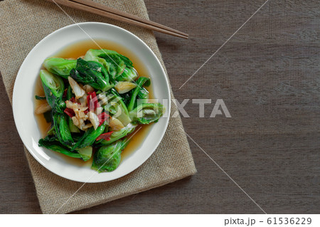 top view of stir fried cabbage sprout with soy sauce in a ceramic dish on wooden table. 61536229