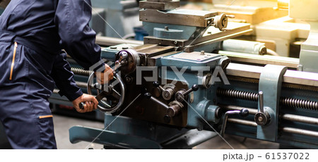 Factory Asian male worker. Asian man Lathe worker in production plant drilling at machine on the factory. Yellow hard hat safety first at mechanic factory. 61537022