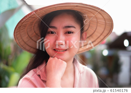 Portrait young beauty Asian woman wearing straw Vietnamese hat with smiley face  61540176