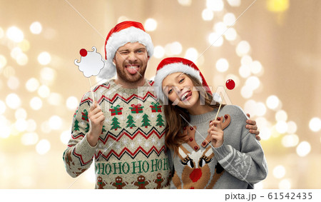 couple with christmas party props in ugly sweaters 61542435