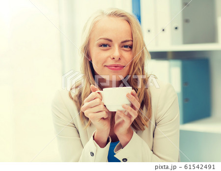 happy businesswoman drinking coffee at office happy businesswoman drinking coffee at office 61542491