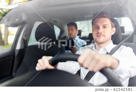 male driver driving car with passenger male driver driving car with passenger 61542581