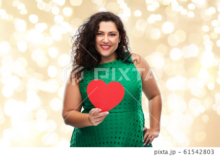 happy woman holding red heart over lights 61542803