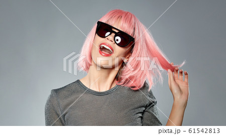 happy woman in pink wig and black sunglasses 61542813