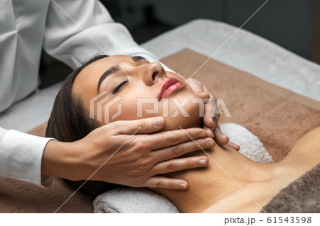 woman having face and head massage at spa woman having face and head massage at spa 61543598