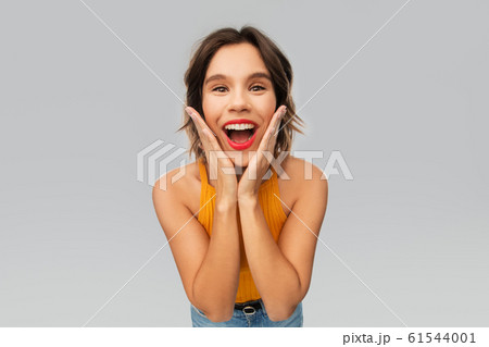 surprised young woman in mustard yellow top surprised young woman in mustard yellow top 61544001